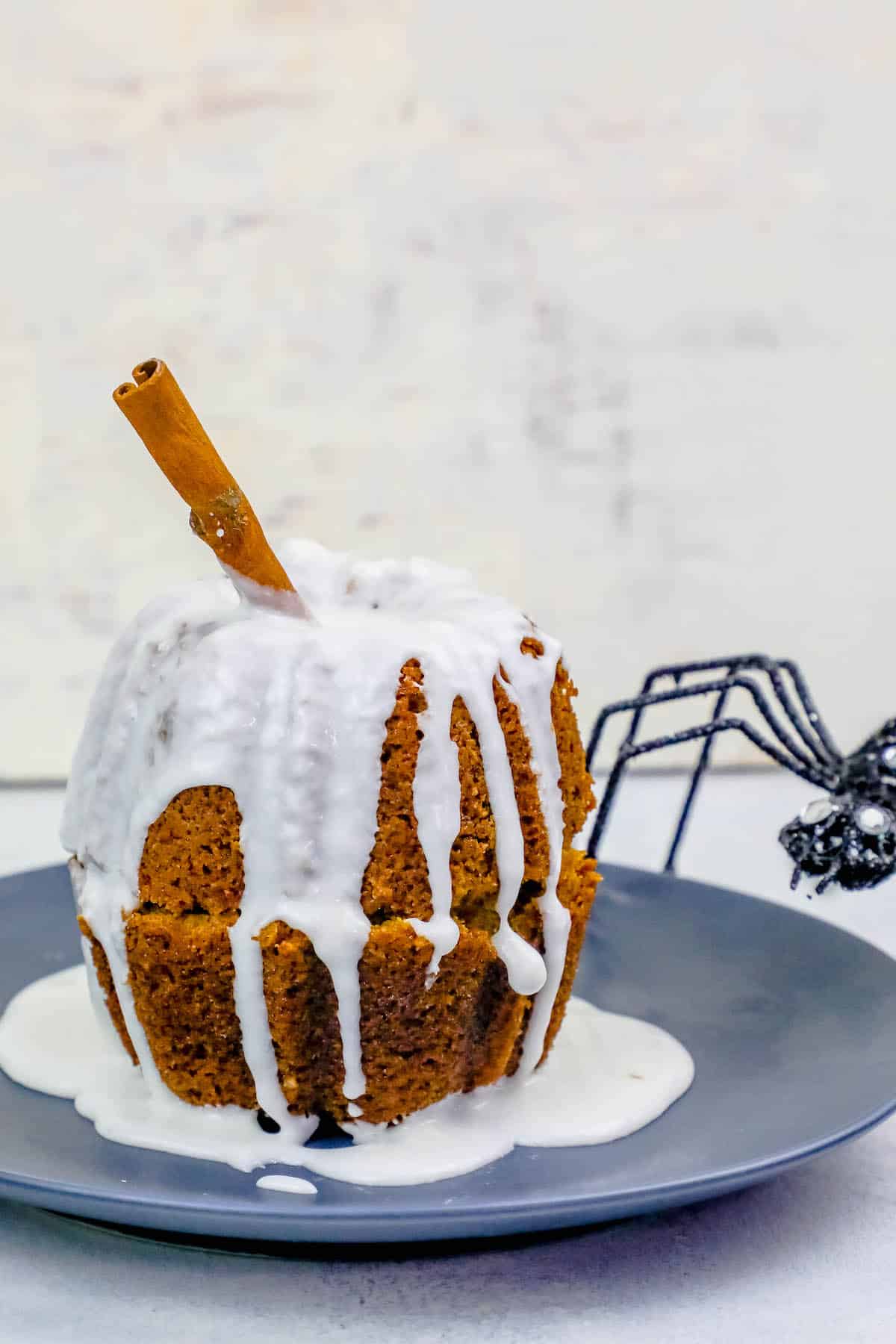 pumpkin Bundt cake together with cinnamon stick in it and white glaze
