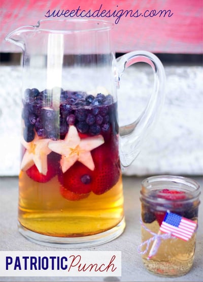 patriotic punch in pitcher with strawberries, blueberries, and star shaped apples