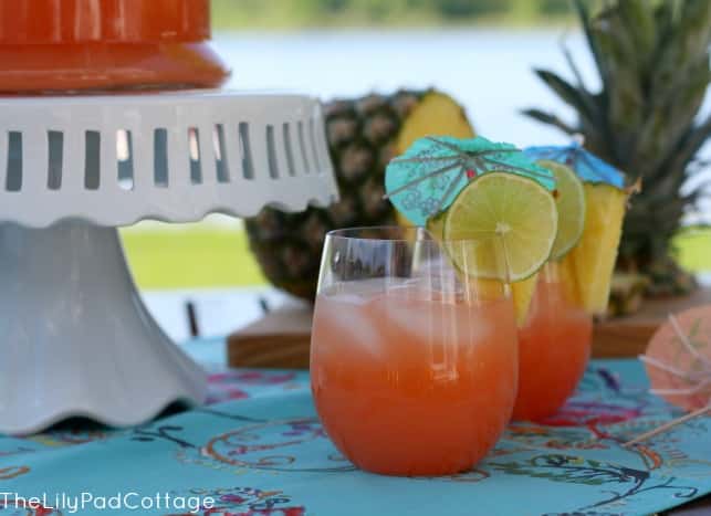 Hawaiian Rum Punch with pineapples and limes on a table.