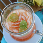 A pitcher of pineapple limeade with lime slices and Rum Punch.