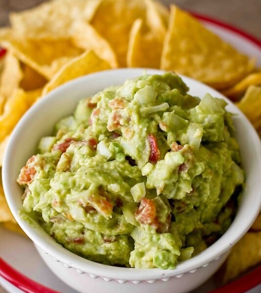 Green chili guacamole served with chips.
