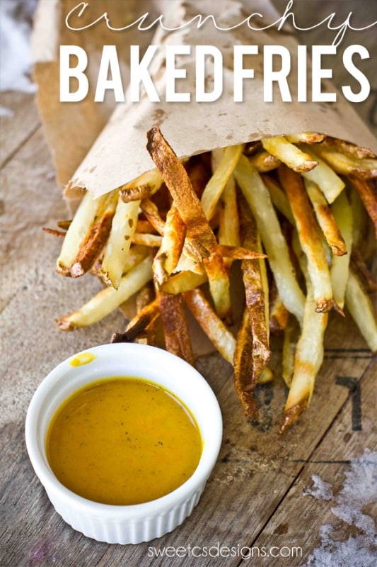 crispy baked french fries in a metal bowl spilling out onto brown paper