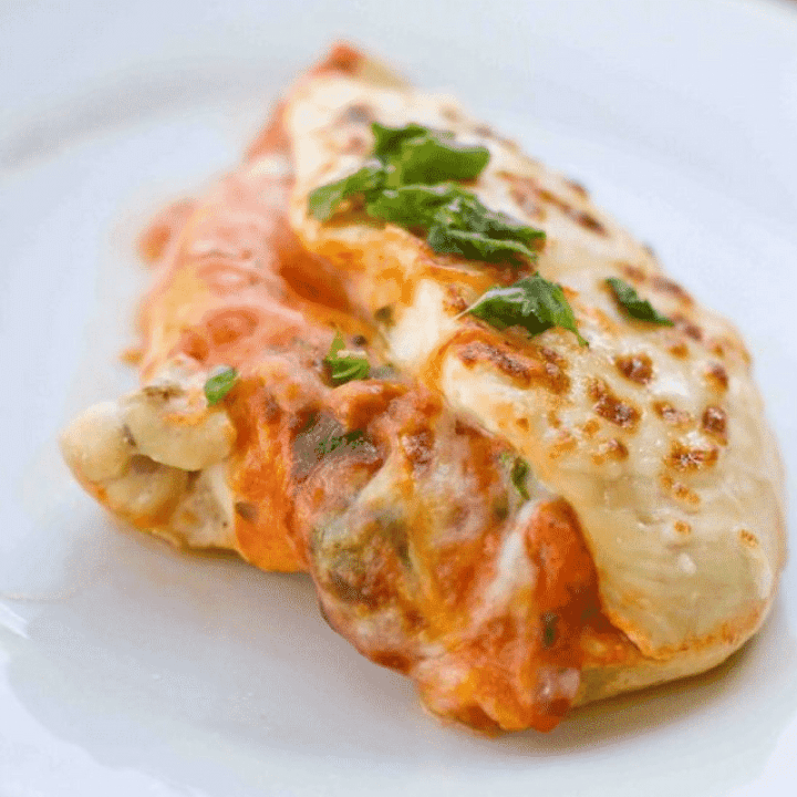 A baked Stuffed Chicken Parmesan served on a white plate.