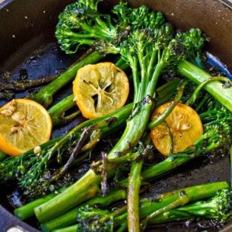 A cast iron skillet filled with broccolini and Meyer lemon slices.