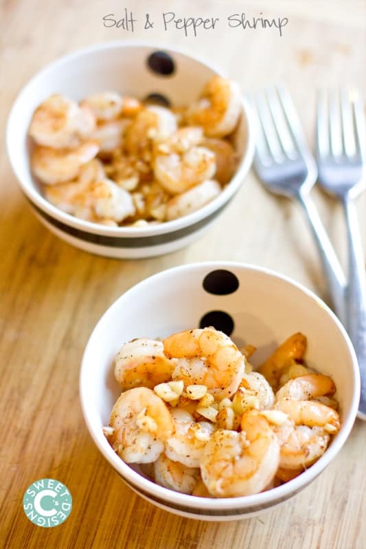 shrimp with salt and pepper and garlic in a bowl on a wooden cutting board