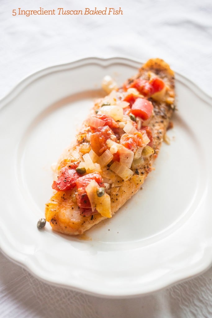 baked fish with capers and tomatoes on it