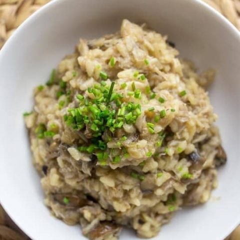 Mushroom risotto in a white bowl with crab.