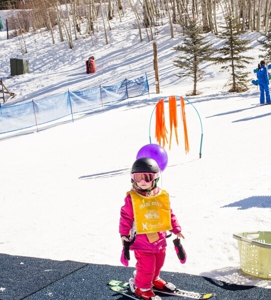 A little girl at Beaver Creek Ski School, skiing in the snow.