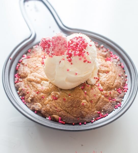 Brown butter blondies served in a skillet with a scoop of ice cream.