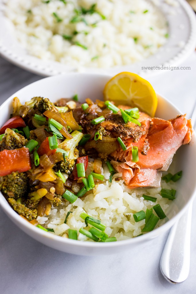 bowl with rice, salmon, broccoli, chives, and lemon in it