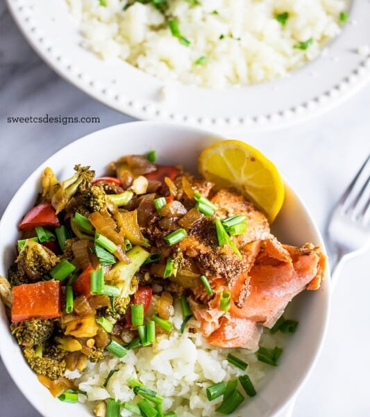 Salmon and vegetables served on a bed of cauliflower rice.