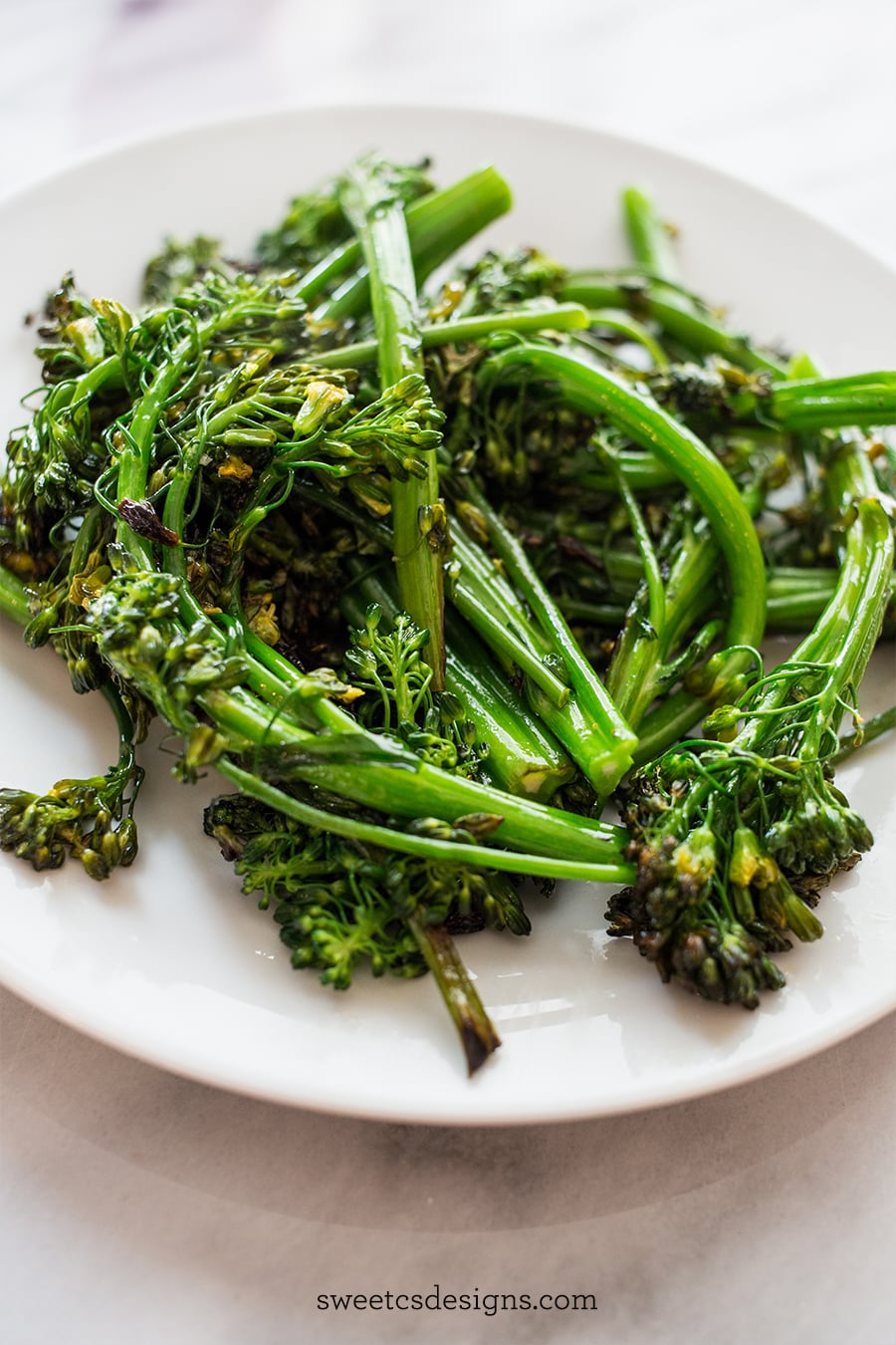 picture of pan fried broccolini on a white plate