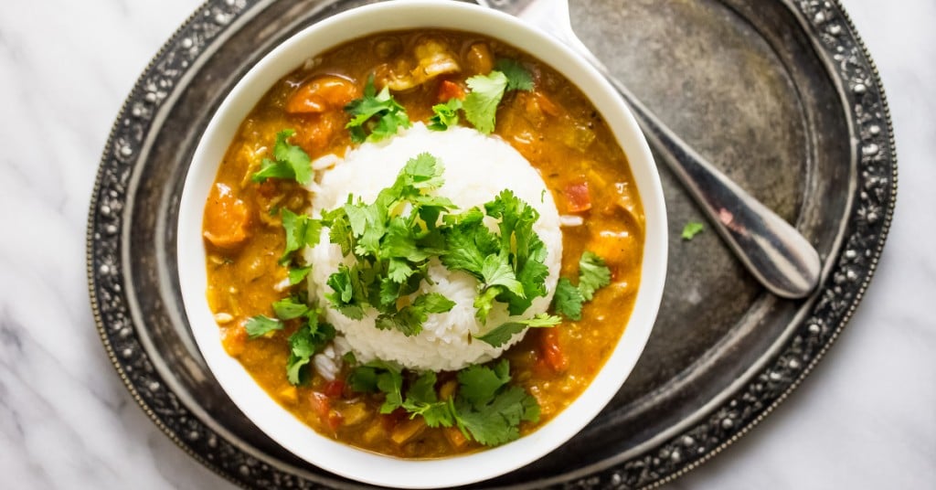 stew with beans and vegetables with rice and cilantro on top