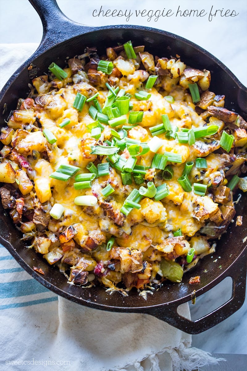 potatoes, zucchini, cheese, and green onions in a cast iron skillet