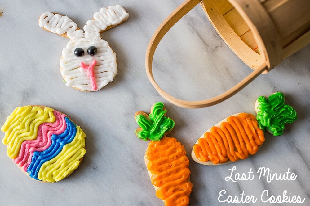 sugar cookies iced to look like an easter egg, a carrot, and a rabbit, basket in the background