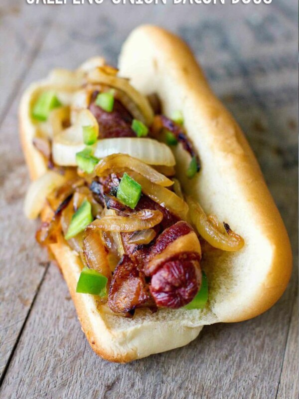 bacon wrapped hot dog on a bun with onions and jalapenos on it