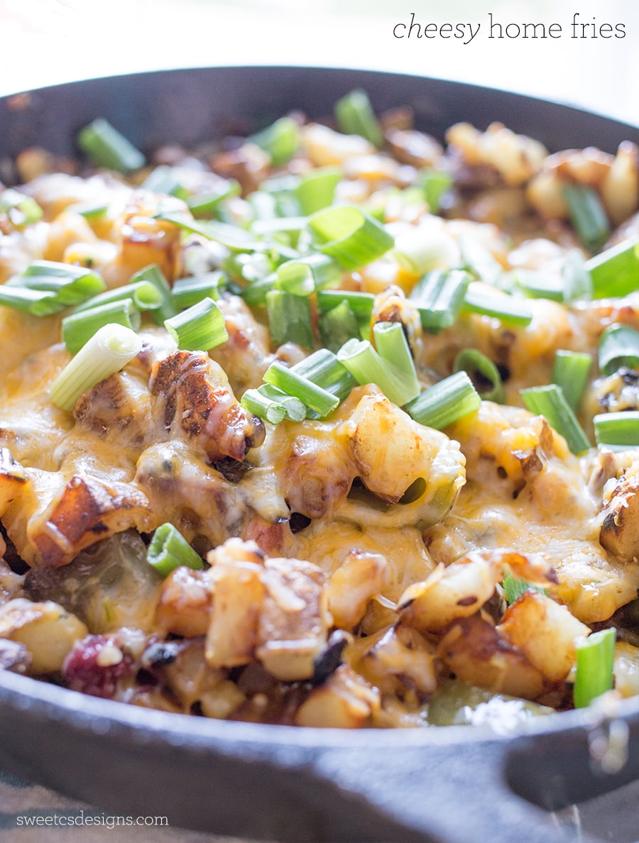 potatoes, zucchini, cheese, and green onions in a cast iron skillet