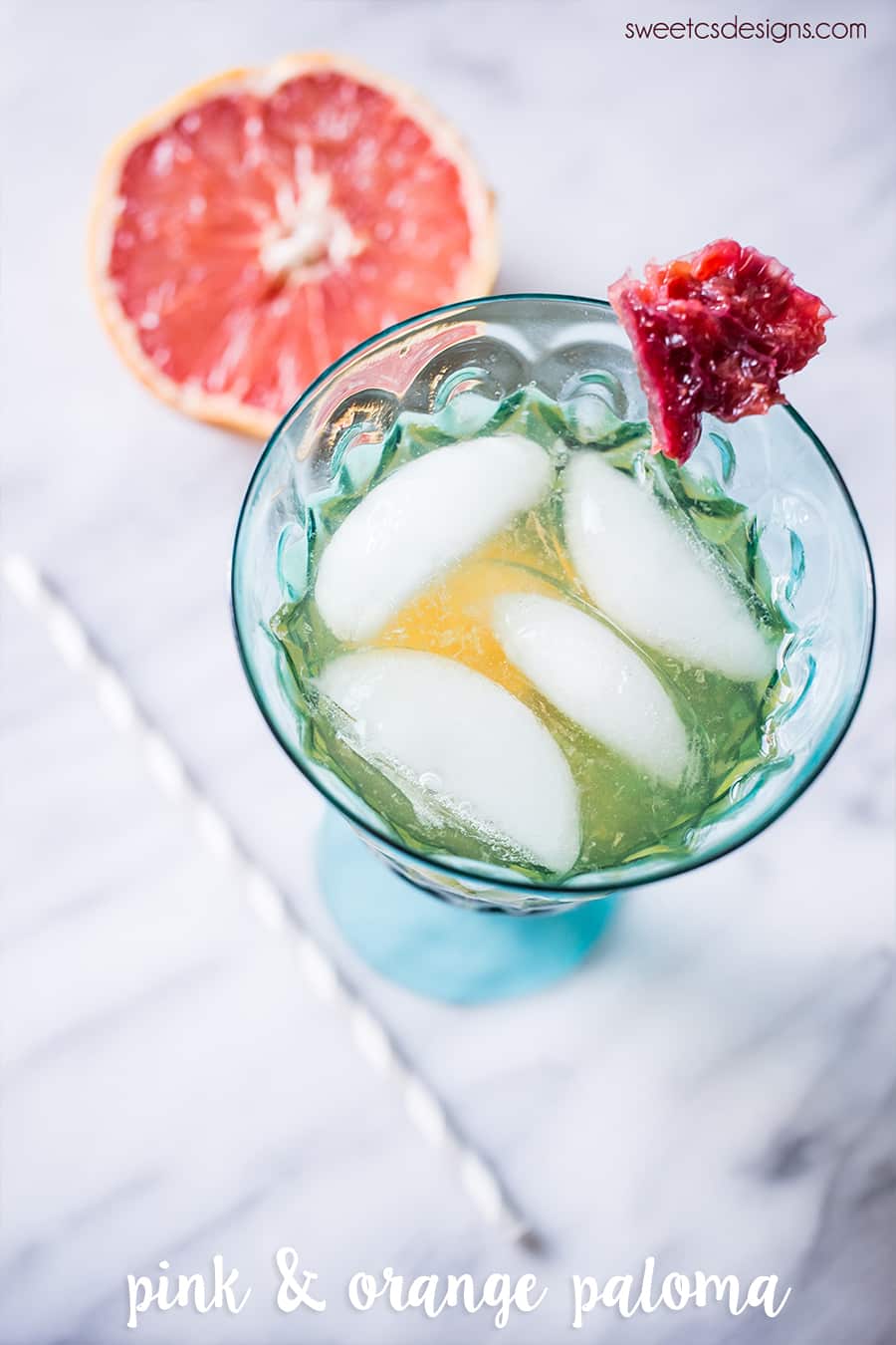 drink with orange in it and ice, grapefruit slice in the background