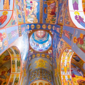 The interior of Lurji Monastery showcases colorful paintings on the ceiling.