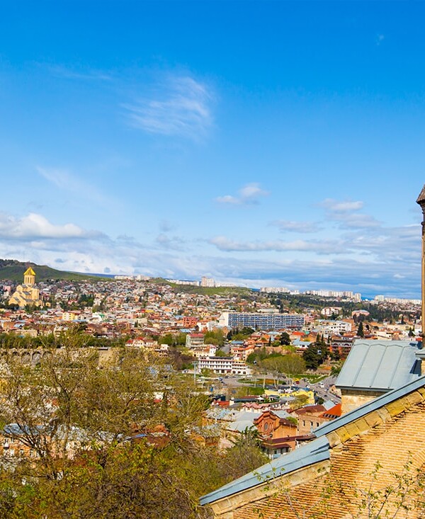 A city with a church on top of a hill, overlooked by the Bridge of Martyrs and Fortress.