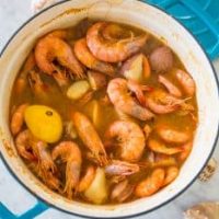 Quick and Easy Shrimp Boil in a blue pot on a marble countertop.