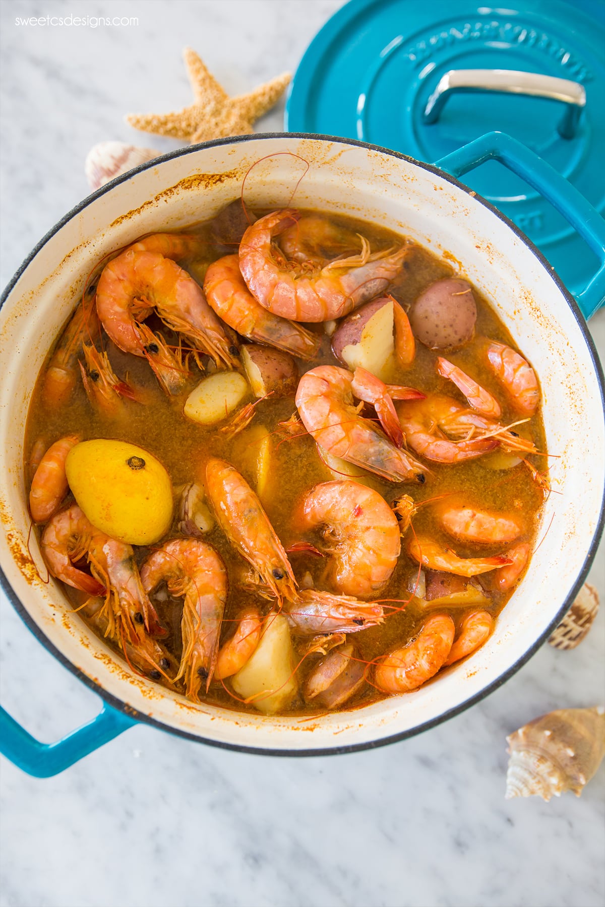 pot with potatoes, shrimp, and sauce in it