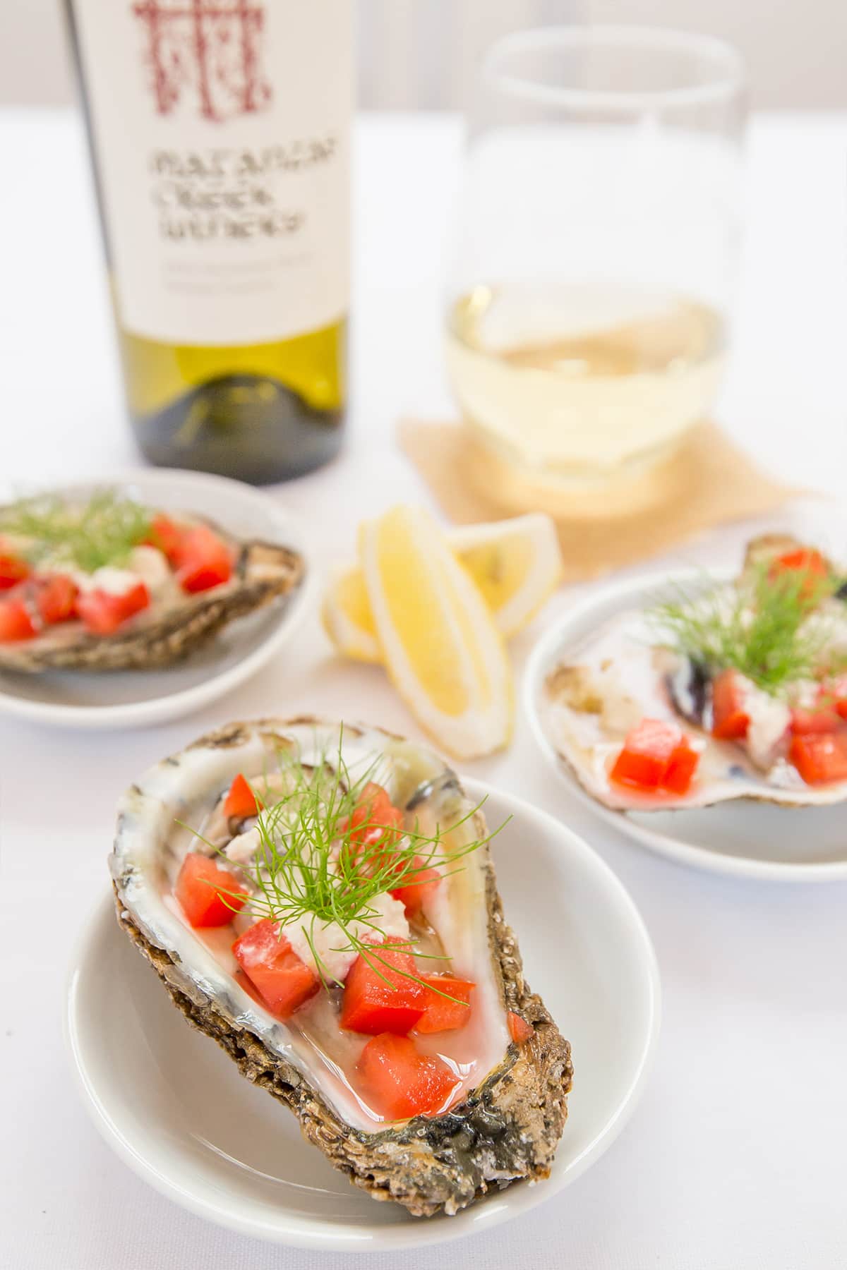 oysters with tomatoes and dill on them