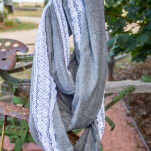 A gray scarf embellished with lace hanging from a tractor.