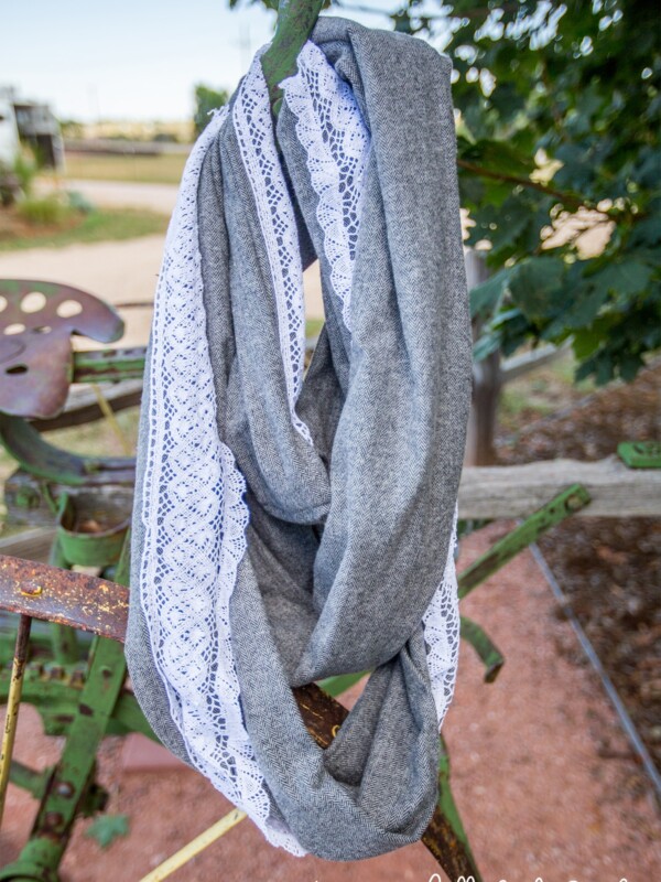 A gray scarf embellished with lace hanging from a tractor.