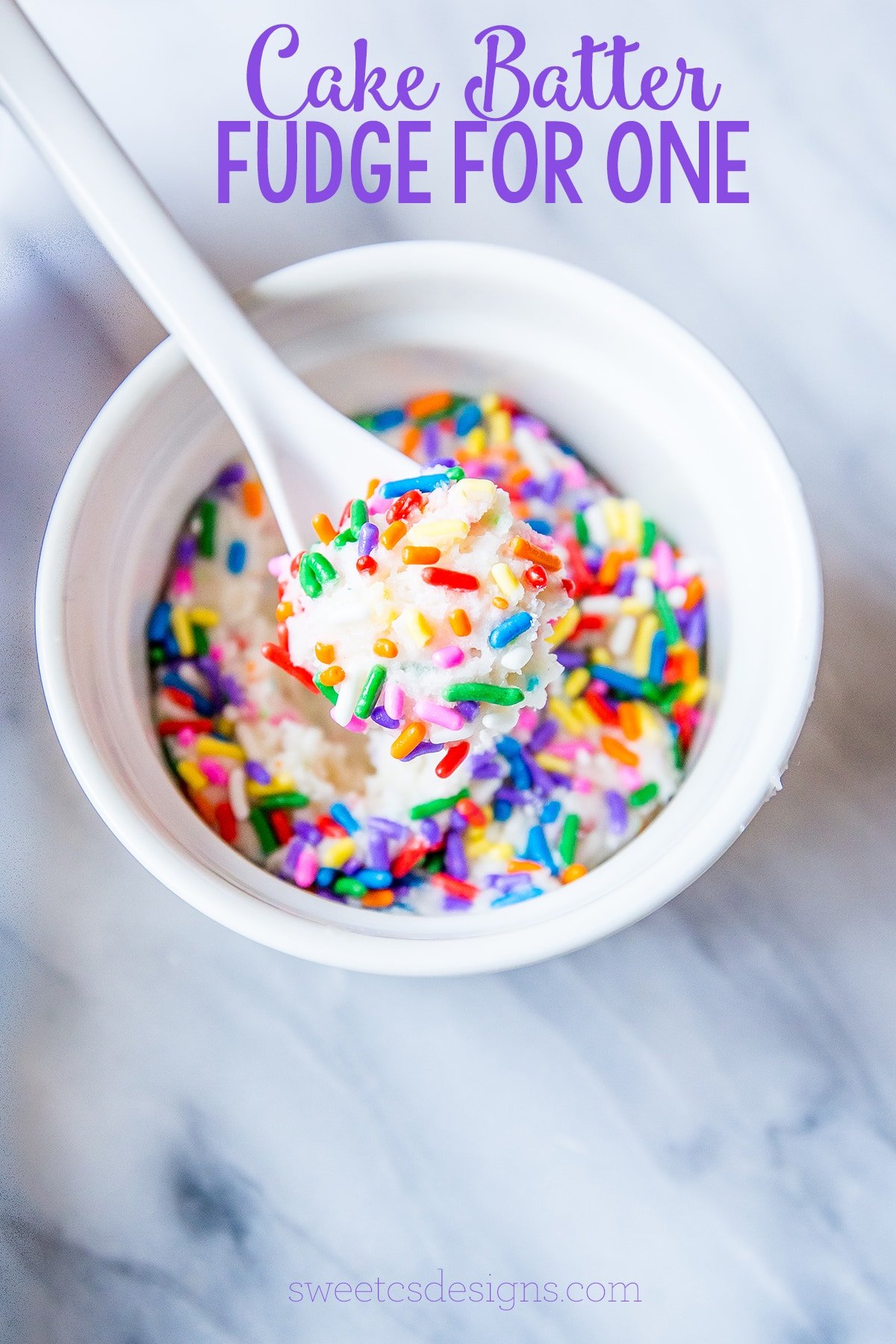 white fudge with sprinkles in a bowl with a spoon