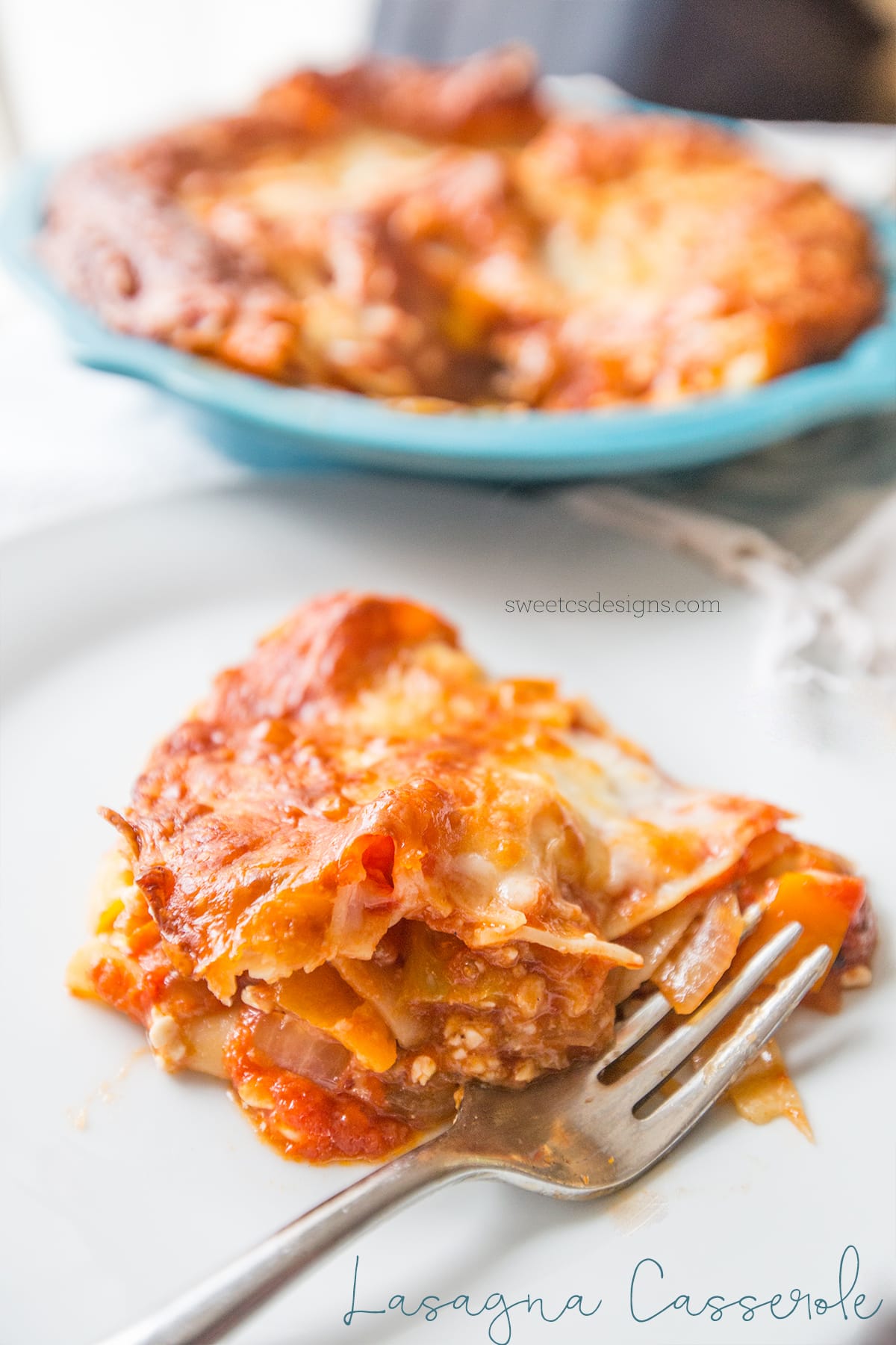 lasagna noodles, cheese, vegetables, and meat layered on a plate with a fork