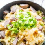 Cheesy sausage potatoes and cabbage skillet dinner.
