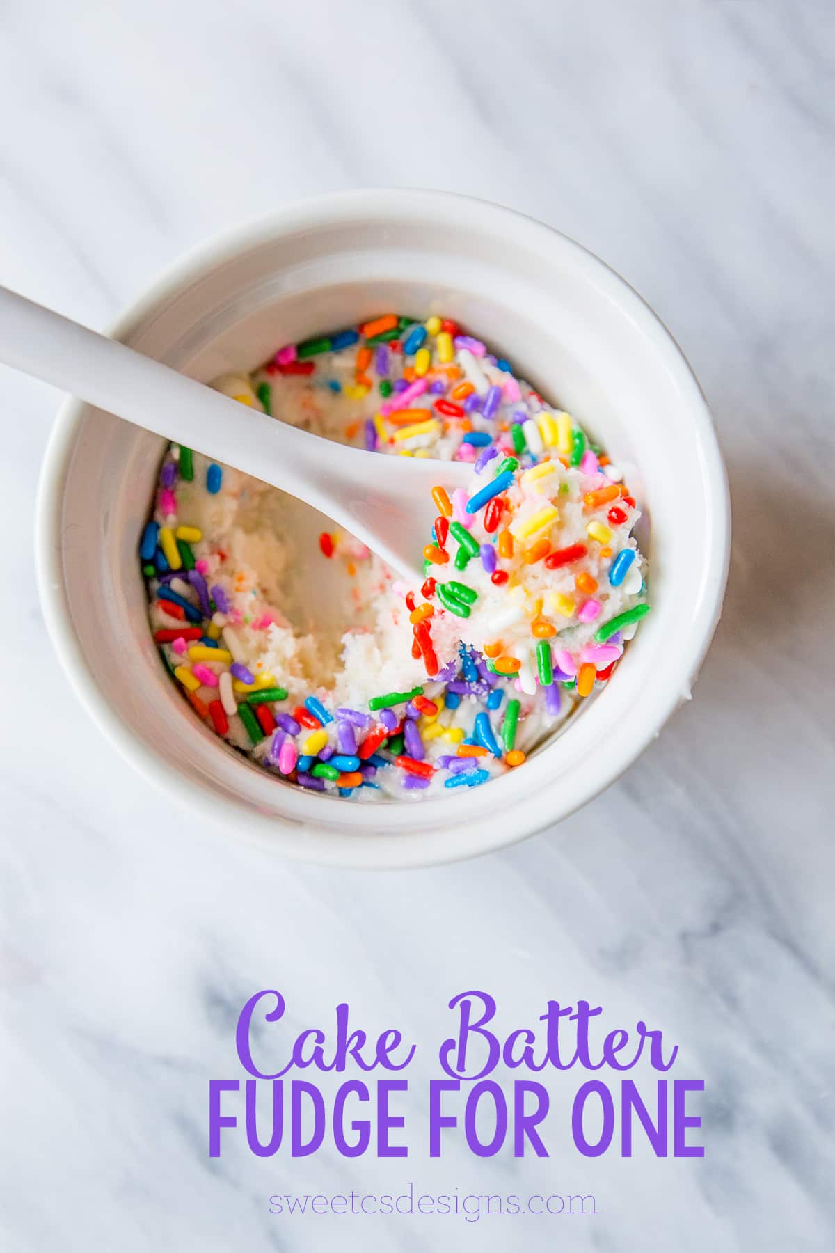 white fudge with sprinkles in a bowl with a spoon