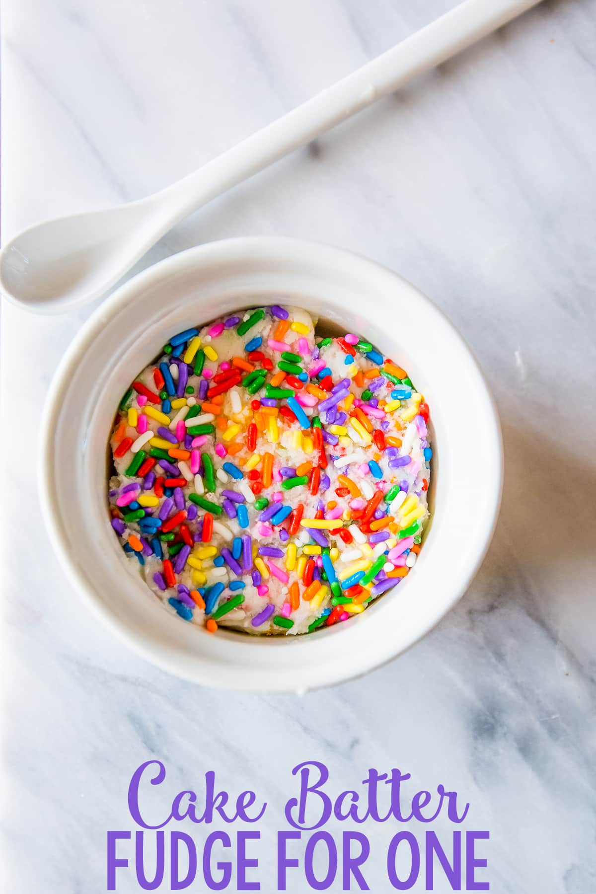 white fudge with sprinkles in a bowl with a spoon