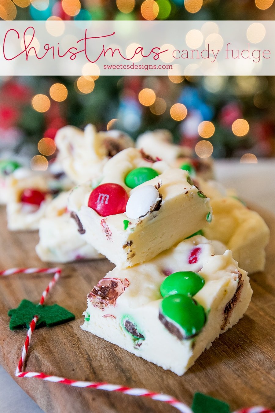 Christmas candy fudge covered in candy on a wooden cutting board with the name on it