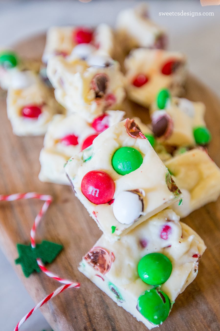 Cookie dough fudge with Christmas candy on a wooden cutting board