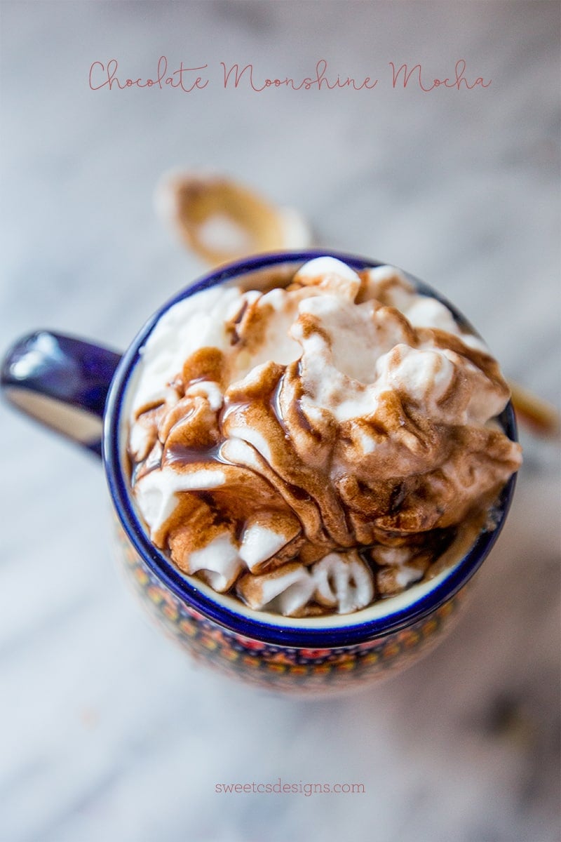 mug with whipped cream and chocolate sauce in the top from above