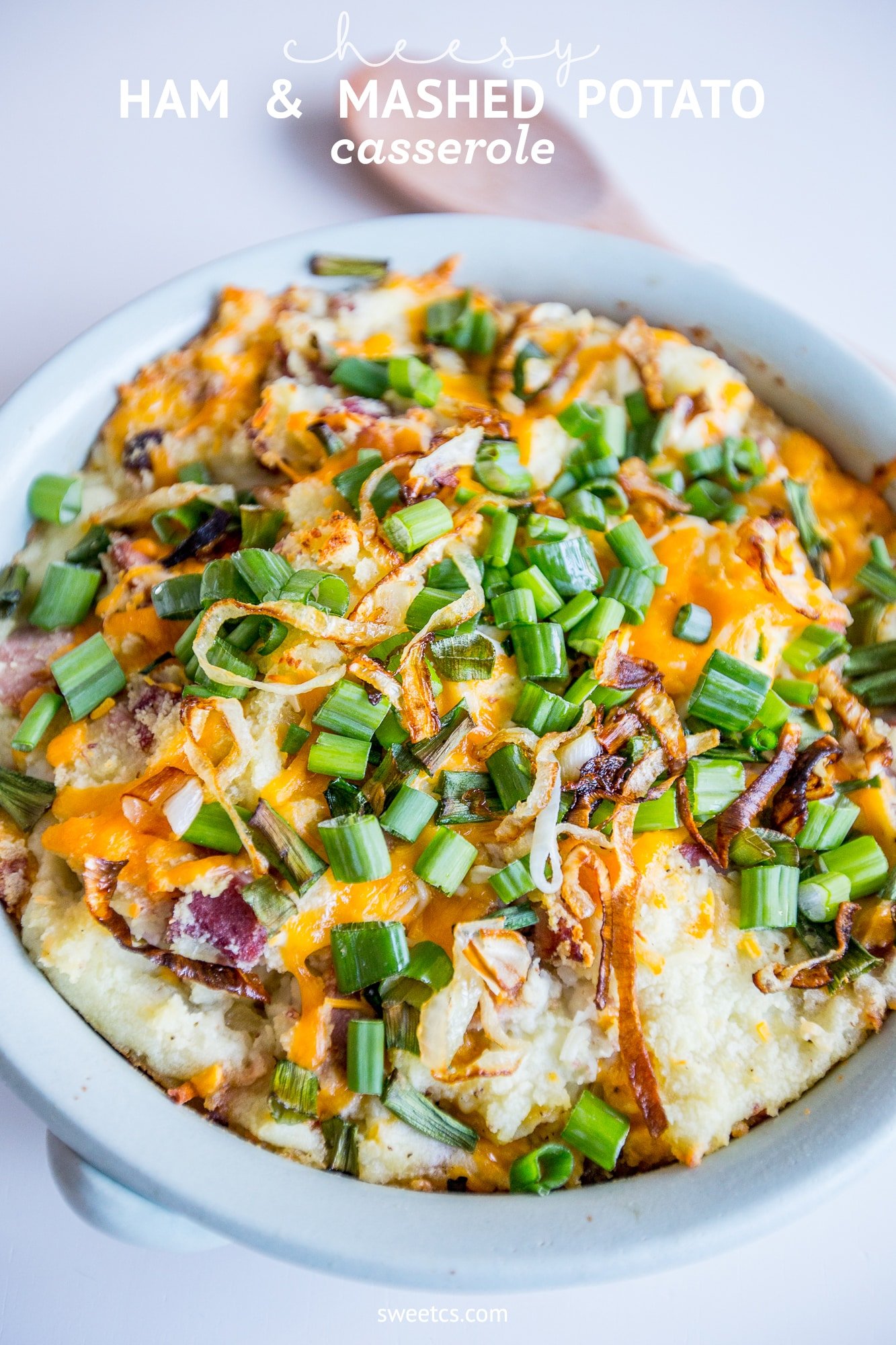 mashed potatoes, cheese, ham, and green onions in a dish