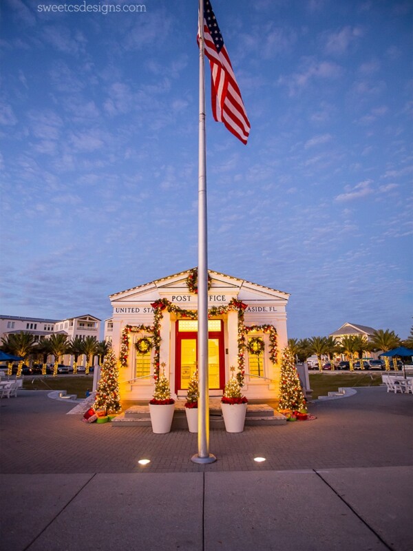 An American flag is flying in front of a white building in Seaside, Florida at Christmas.
