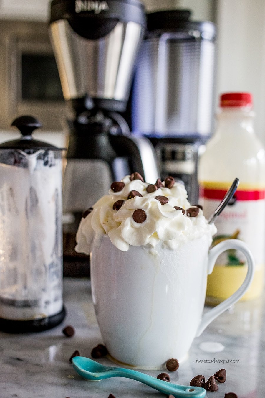 drink in a white mug with whipped cream and chocolate chips