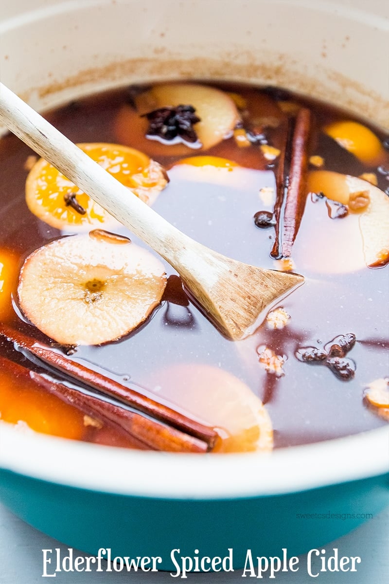 bowl of apple cider with apple, oranges, cloves, cinnamon, and anis