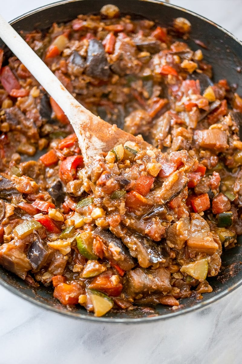 skillet with sauteed vegetables, eggplant, zucchini, tomato, and chickpeas