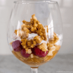 Enjoy a delightful Leftover Pie Parfait in a glass, featuring layers of luscious raspberries, fluffy whipped cream, and a crumbled topping that adds the perfect crunch.