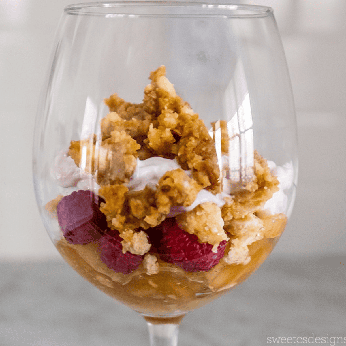 Enjoy a delightful Leftover Pie Parfait in a glass, featuring layers of luscious raspberries, fluffy whipped cream, and a crumbled topping that adds the perfect crunch.