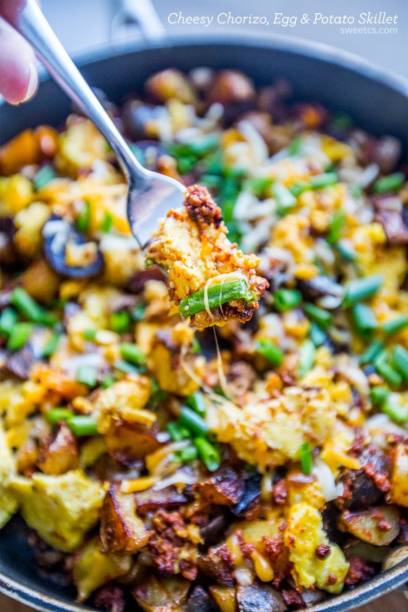 eggs, potatoes, cheese, and green onions in a skillet