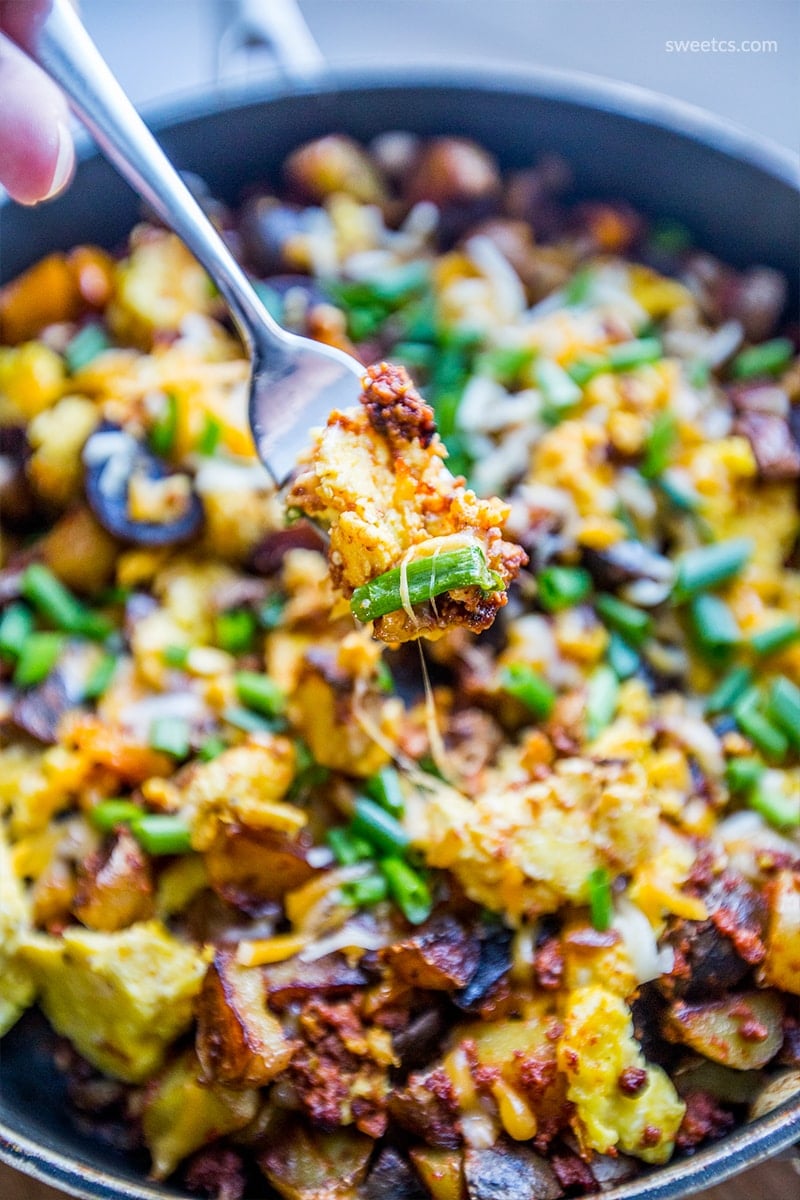 eggs, potatoes, cheese, and green onions in a skillet