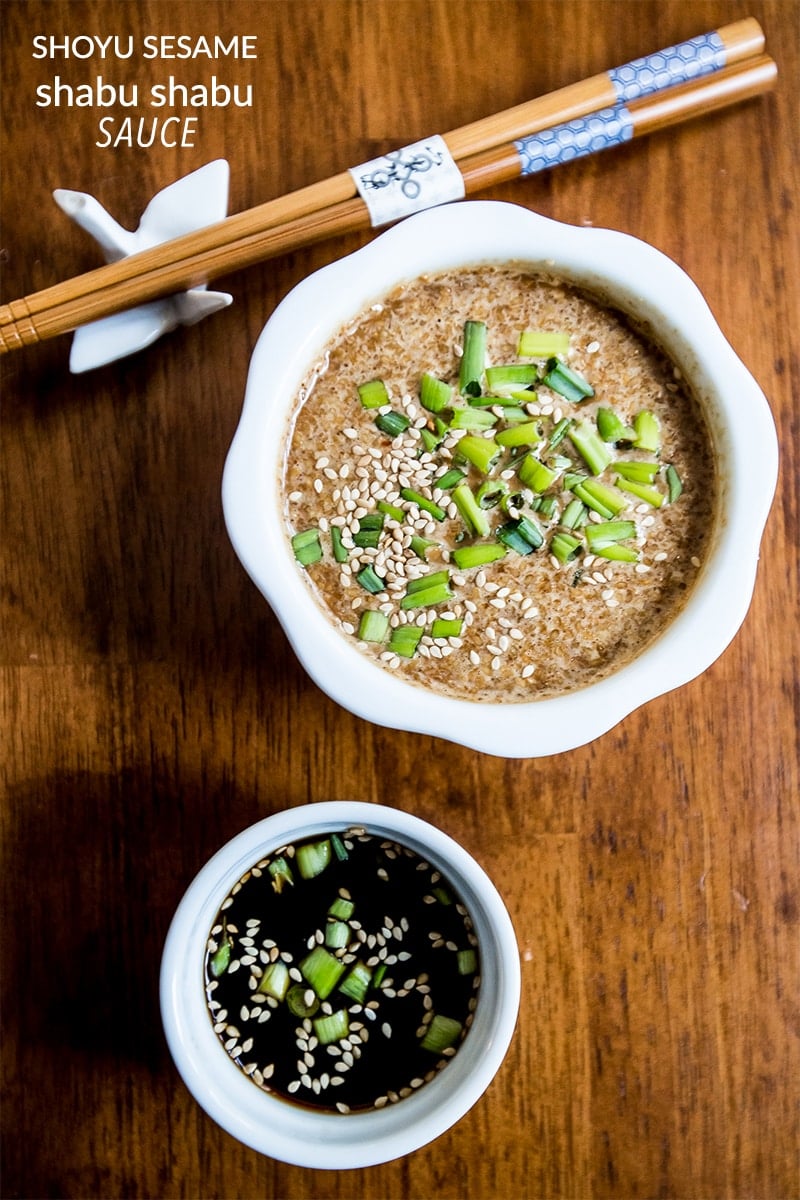 dipping sauce with sesame seeds on it and one dark one with green onions in it with chop sticks in the background