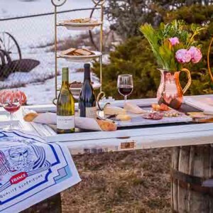 A DIY wine barrel ring light illuminates a table adorned with flowers in the snow.