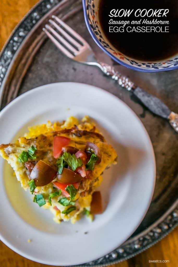 hashbrown egg casserole on a plate with tomatoes and basil on the top. 