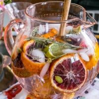 water in a pitcher with oranges, rosemary, detox spices, and ice